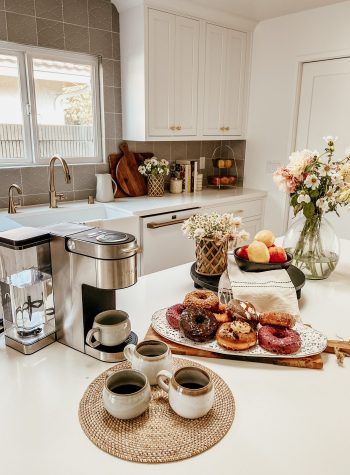 coffee and donut spread on a clean, white, modern counter
